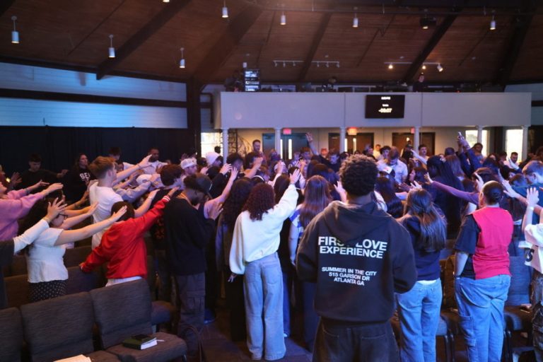 A large group of students prays together inside Bush Chapel.