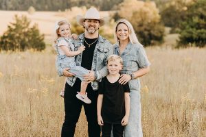 Christian Leaphart with her husband and two children standing in a field.
