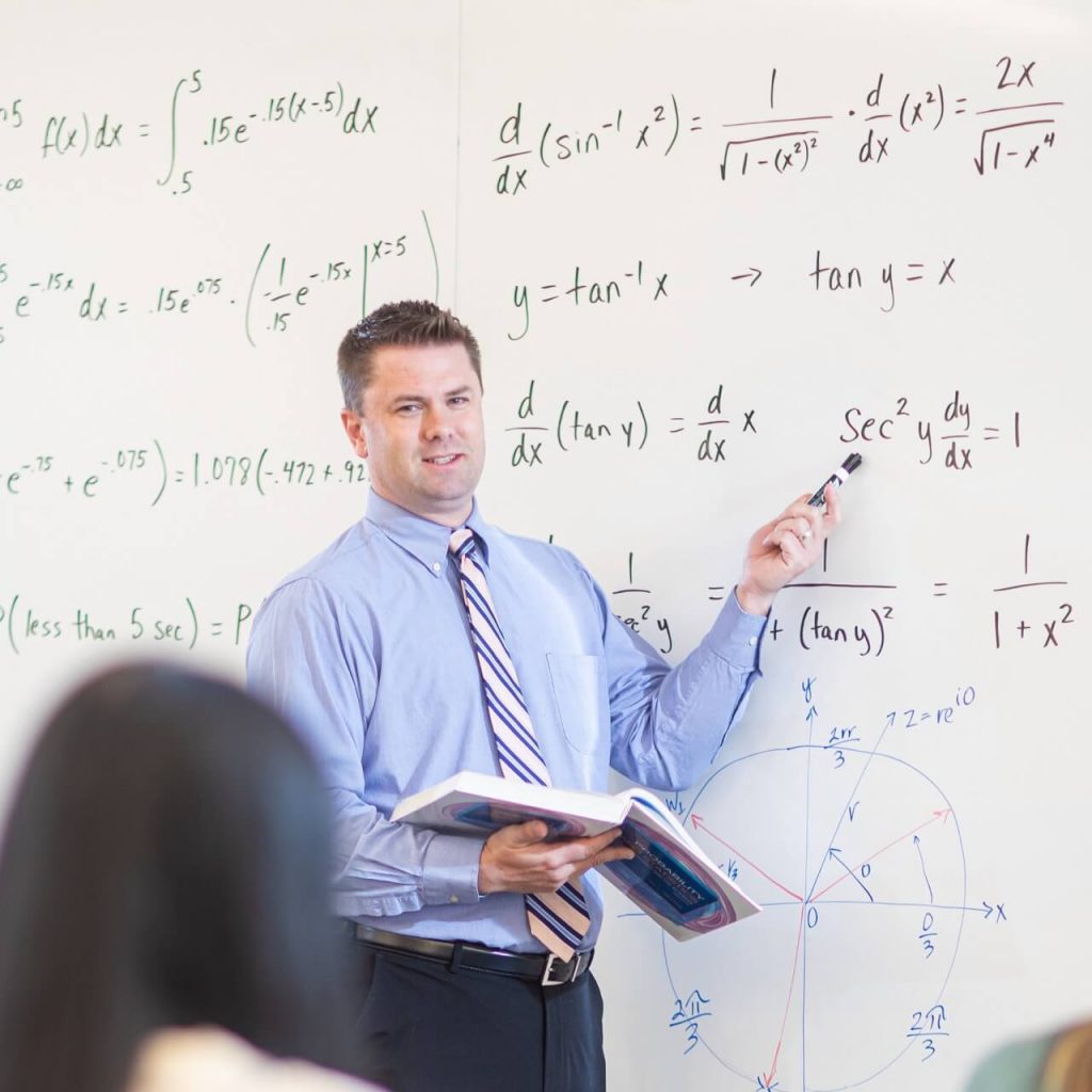 Mathematics educator at whiteboard