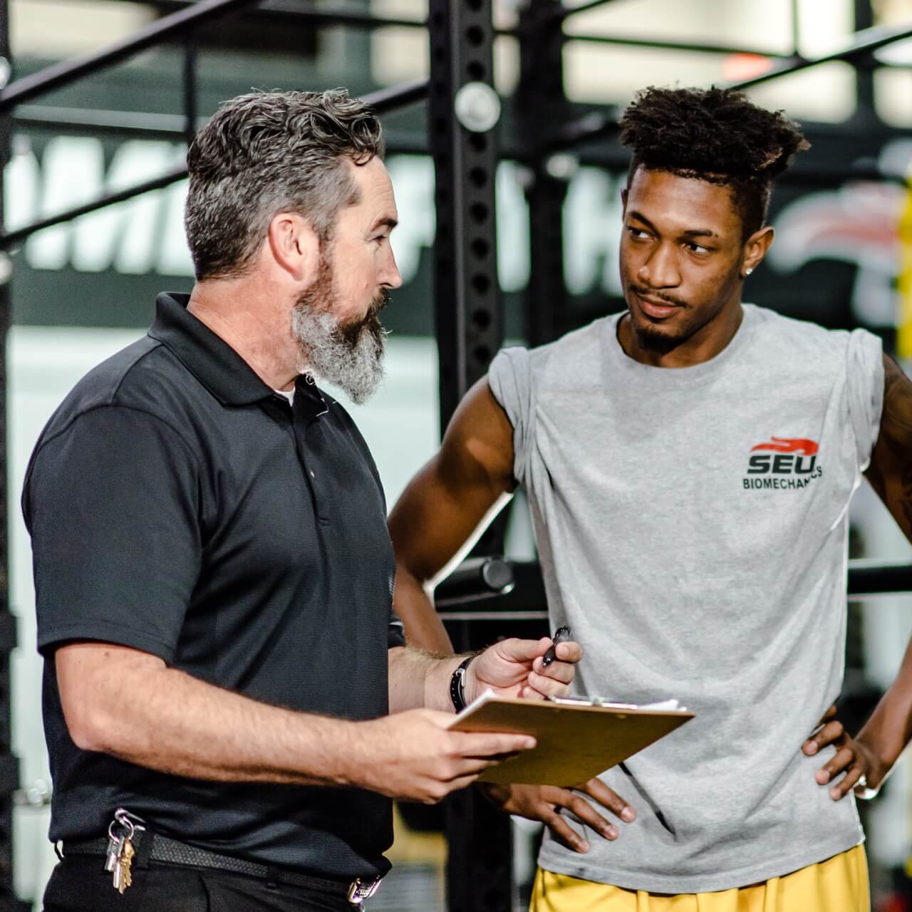 Student and coach in weightlifting gym