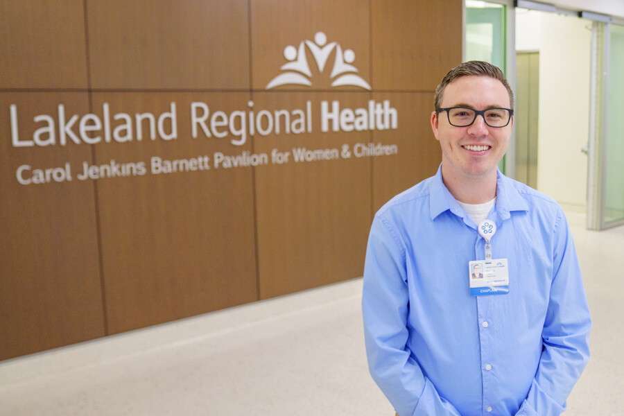 Devon Barnett standing in front of a Lakeland Regional Health logo