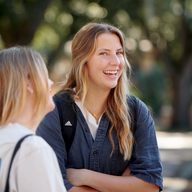 Female students laughing with friends on SEU's campus