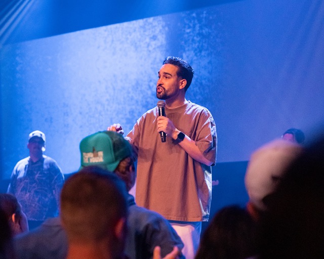 Campus pastor, Jonathan Rivera, speaking on stage at a chapel service.