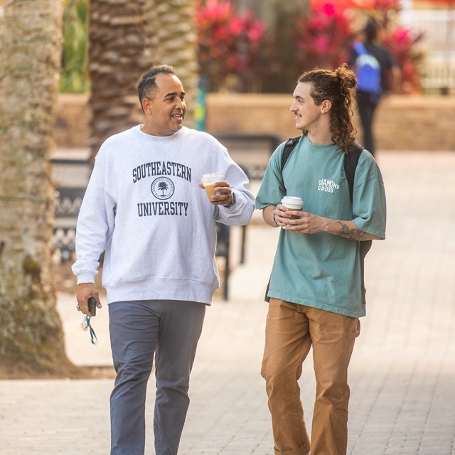 Male student and professor walking down El Prado