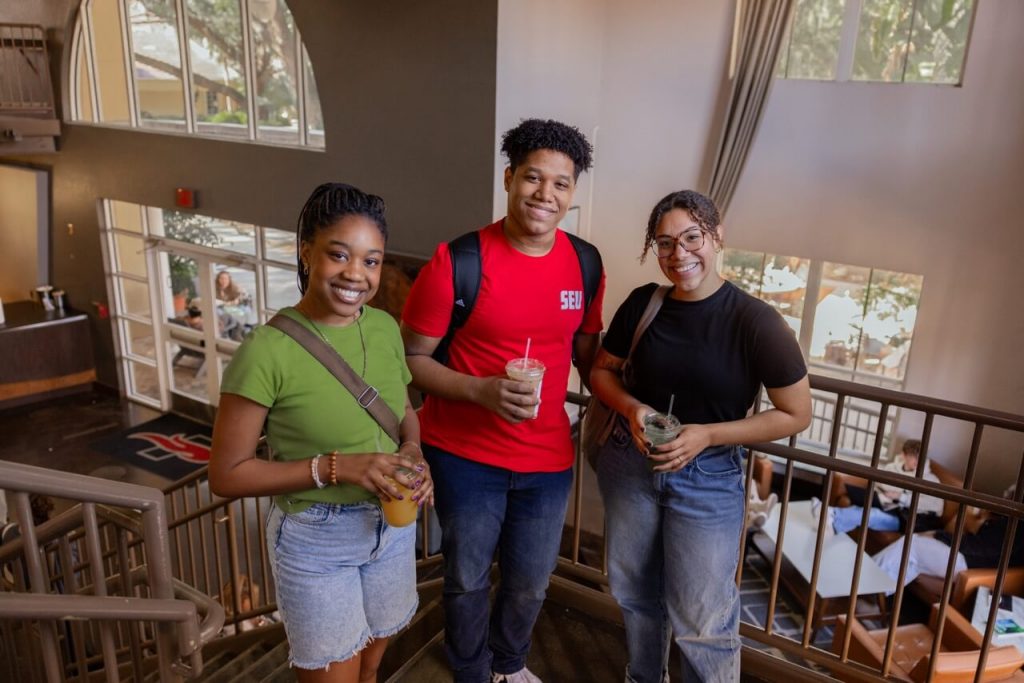 Three students standing inside Portico Coffeehouse