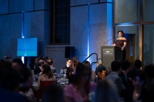 Nathalie Rincon on a stage speaking at an event.