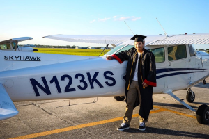 SEU aviation graduate standing in front of a plane.