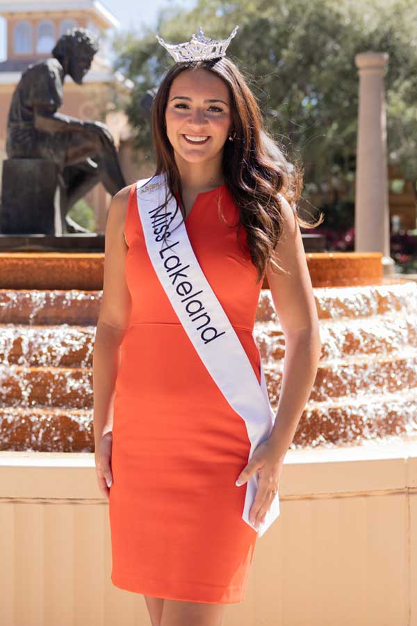 SEU student, Maci Miotto, wearing Miss Lakeland 2025 sash in front of fountain