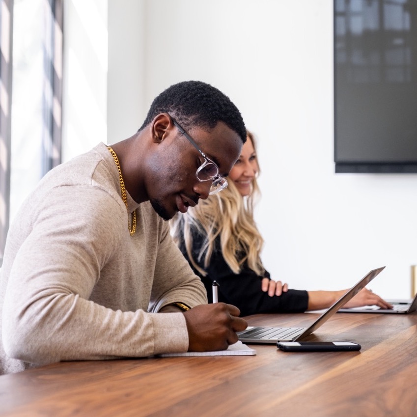 male sitting at a table on a laptop