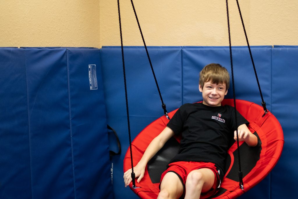 Pathways student on swing smiling