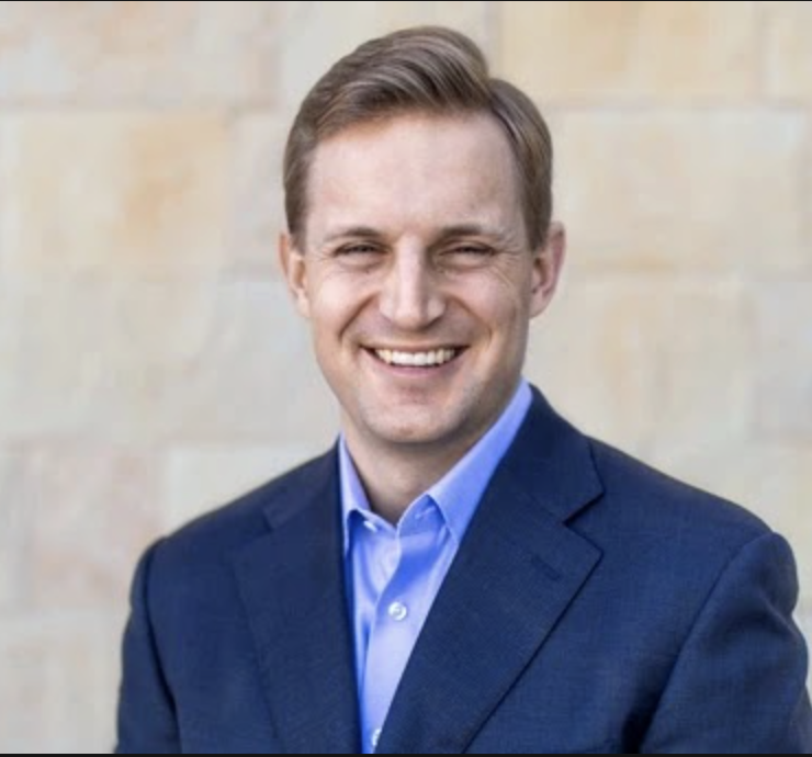 A headshot of a man in a suit.