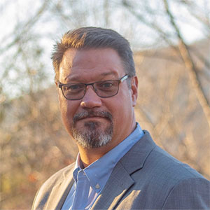 Headshot of a man outside.