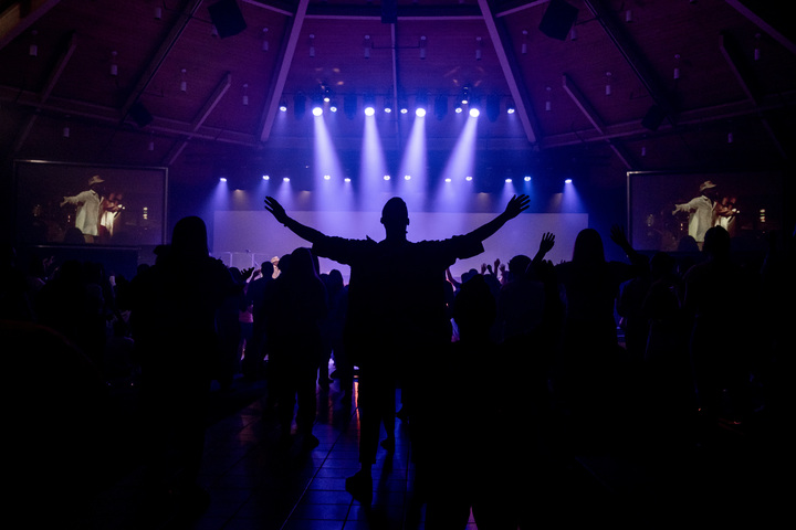 Man stretching his hands out during worship in chapel