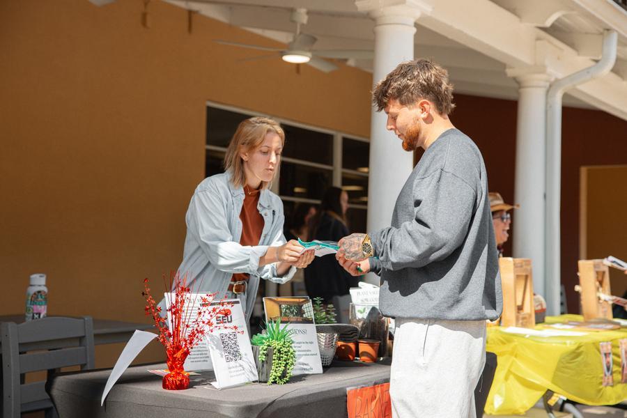 Student standing in front of an SEU resource table at first-gen college student event.