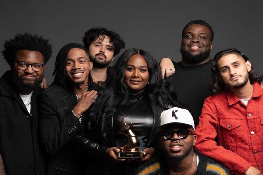 A group of musicians holding a Grammy Award