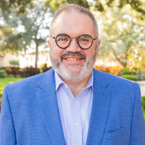 Headshot of a man outside.